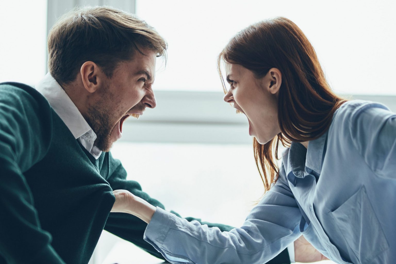 A man and a woman are sitting at a table talking, quarreling with each other, a real quarrel, household issues A man and a woman are sitting at a table talking, quarreling with each other, a real quarrel, household issues